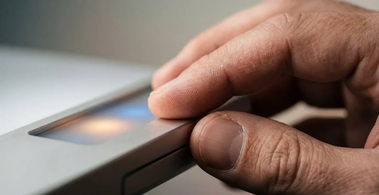 Macro detail of human hand interacting with abstract technological element representing human oversight in AI systems